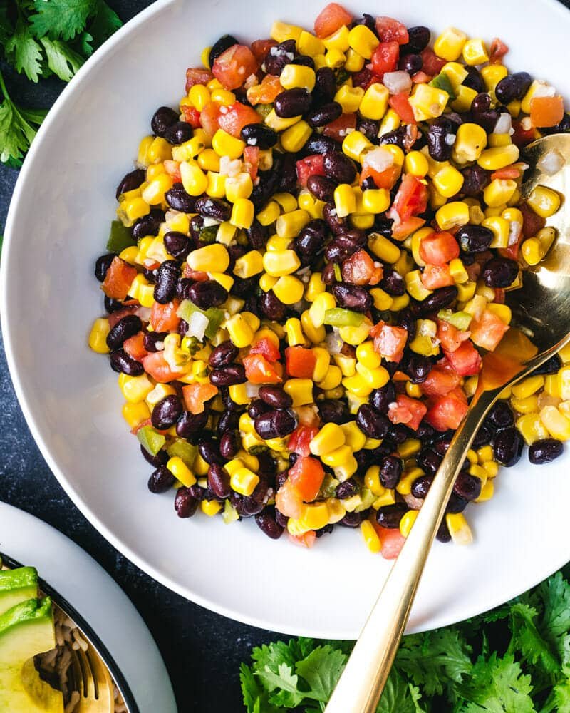 Black bean and corn salad in bowl with spoon.