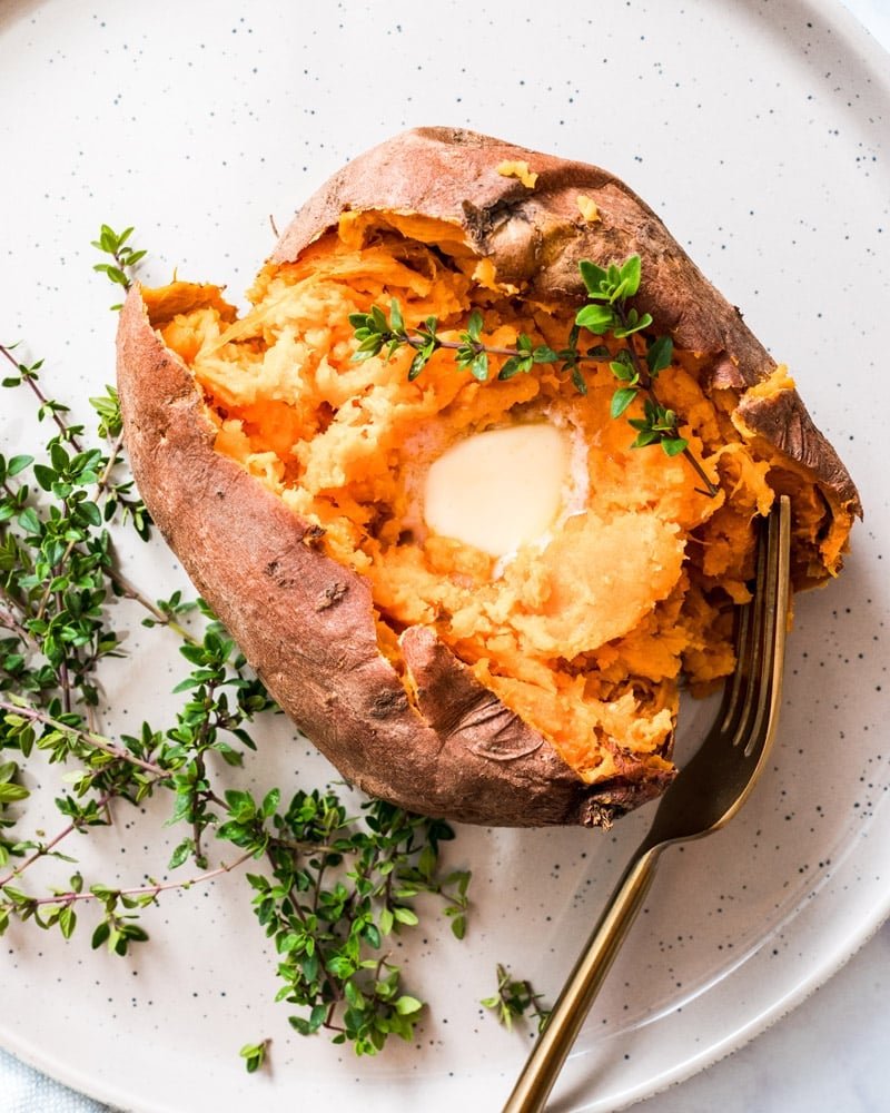 Microwave Sweet Potatoes with butter on plate.